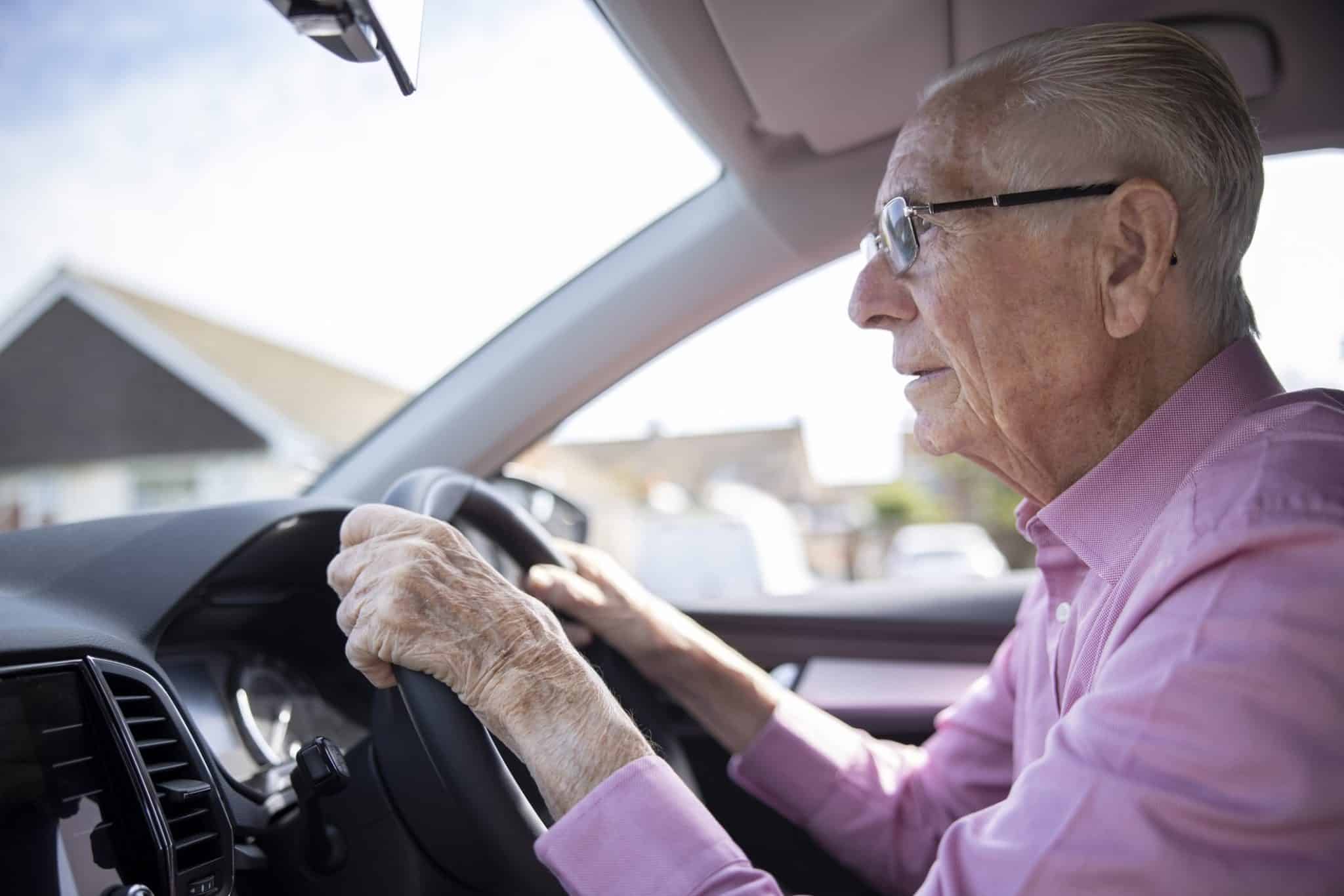 Une personne âgée conduit une voiture attentivement